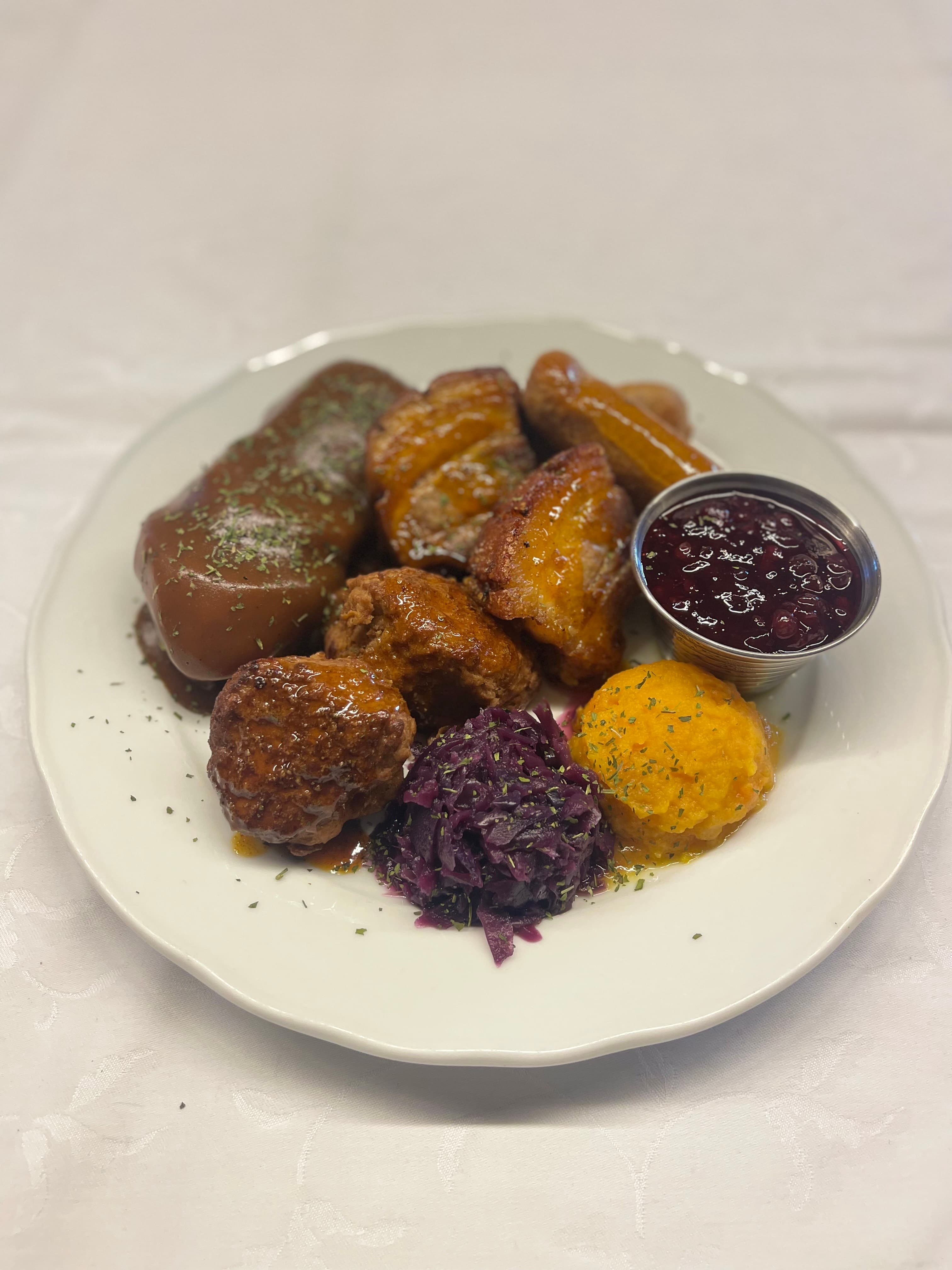 Tradisjonell tallerken med pølse, kålrotstappe og rødkål