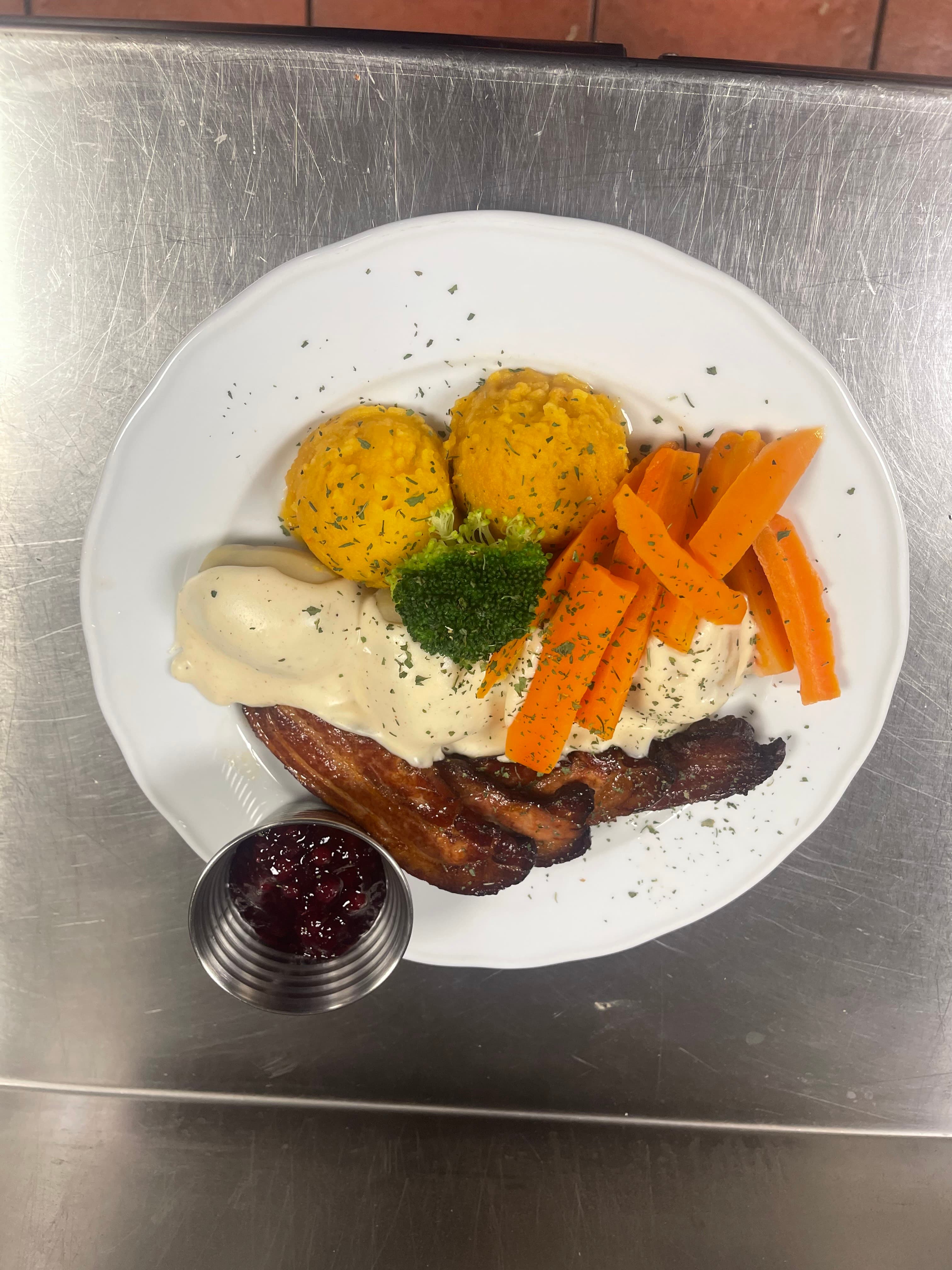 Sprøstekt svinekjøtt med fløtesaus og tyttebær